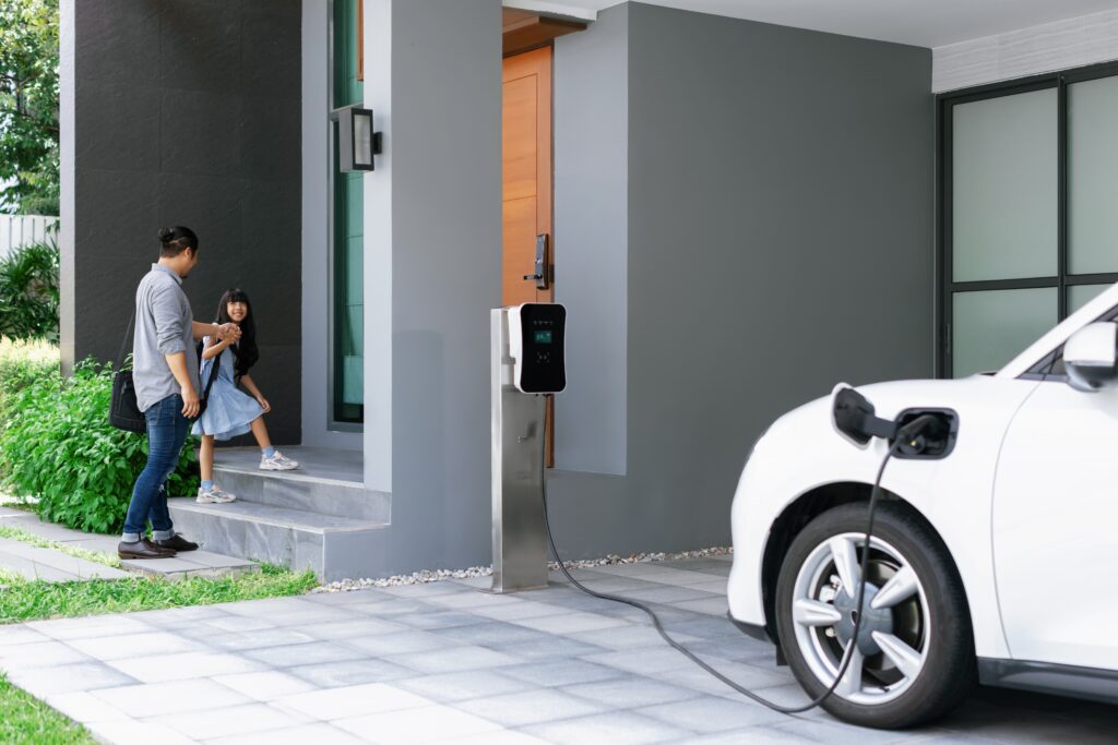 a car parked in a driveway being charged by a Level 2 charger