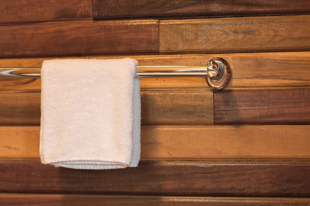 A towel rack on a wood panel wall
