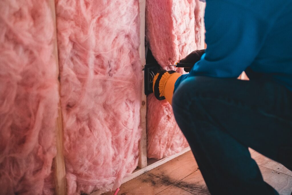 a worker installing insulation in a home