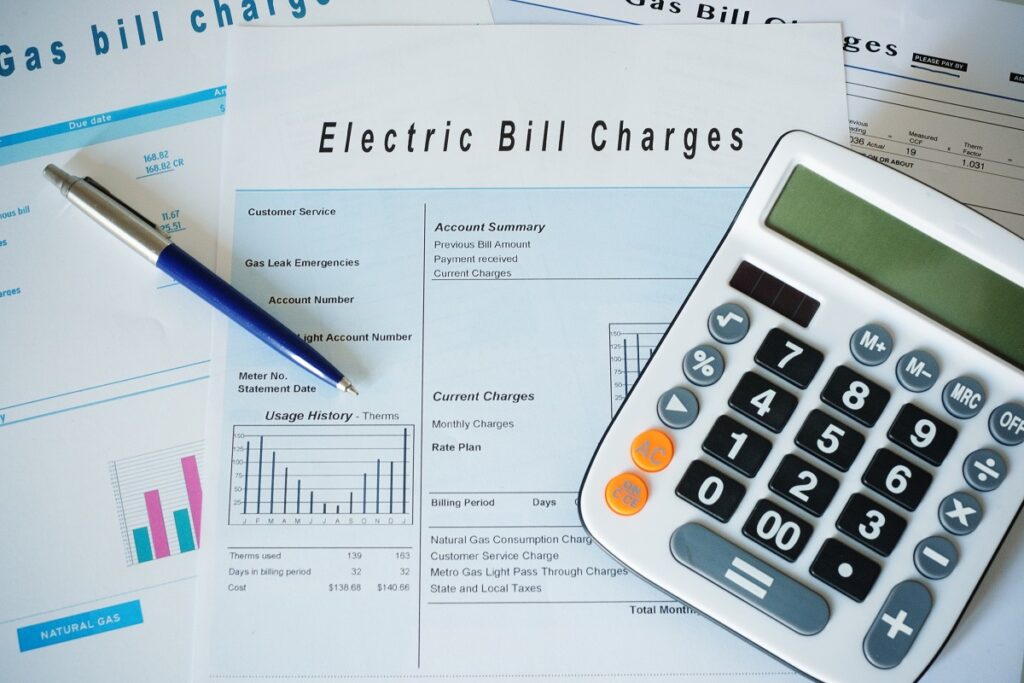 Utility bills on a table with a calculator