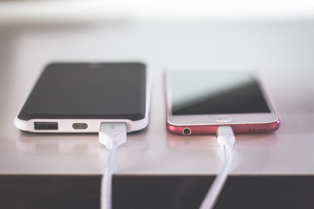 Two cell phones charging on a desk